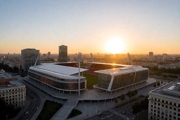城市体育场鸟瞰图，现代化体育场馆和周边建筑的全景展示，夕阳下的运动设施轮廓
