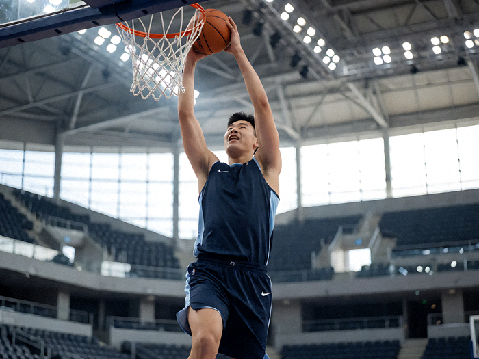 NBA篮球比赛中球员空中扣篮的动感瞬间，球馆内灯光璀璨